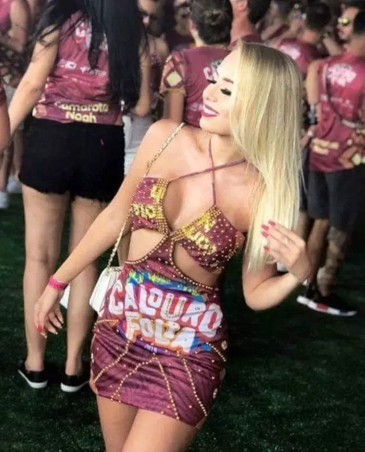 Mulher de pele clara com abadá vinho customizado em vestido com pedrarias