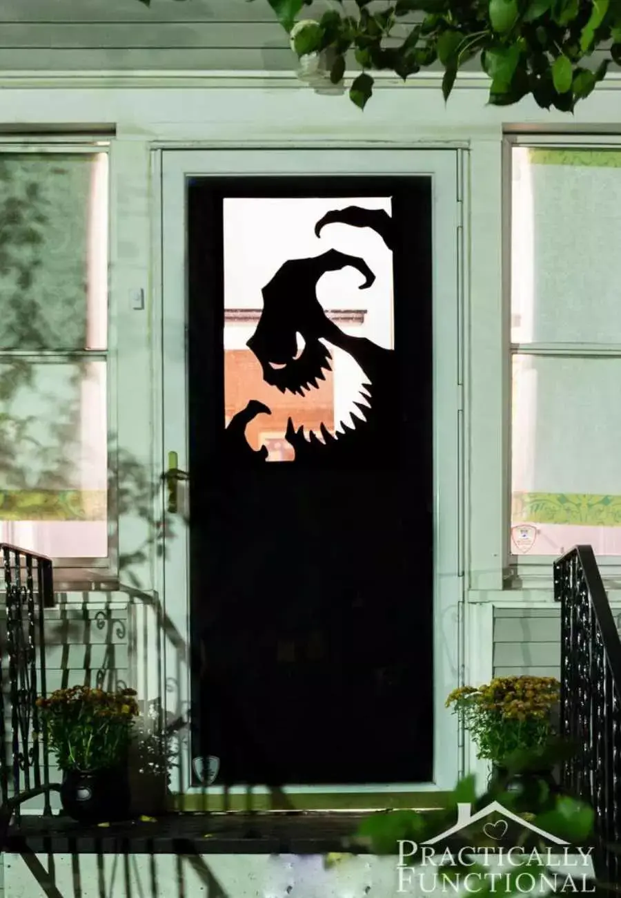 Adesivo de monstro colado em vidro na entrada da casa
