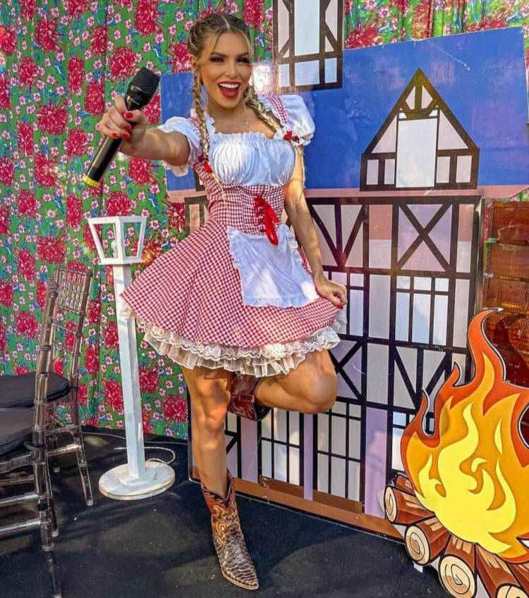 Mulher com vestido quadrilha nas festas juninas, segurando microfone