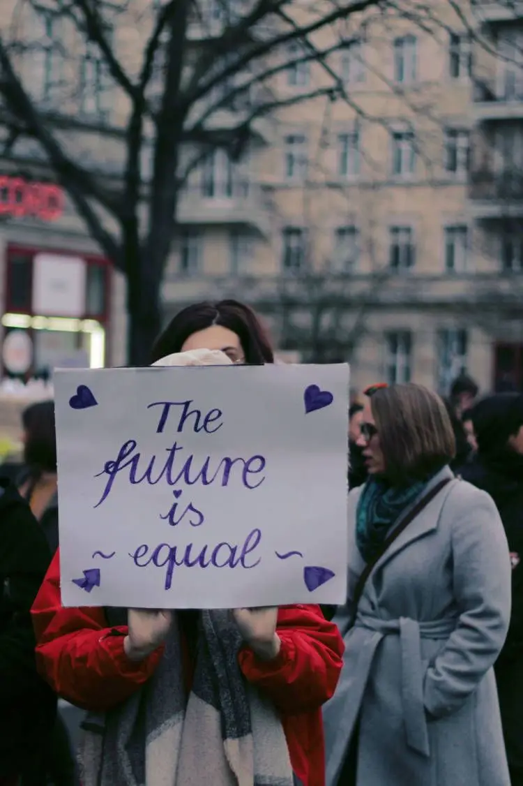 Mulher em protesto segurando cartaz dizendo "the future is equal", ou seja, O futuro é igualitário.