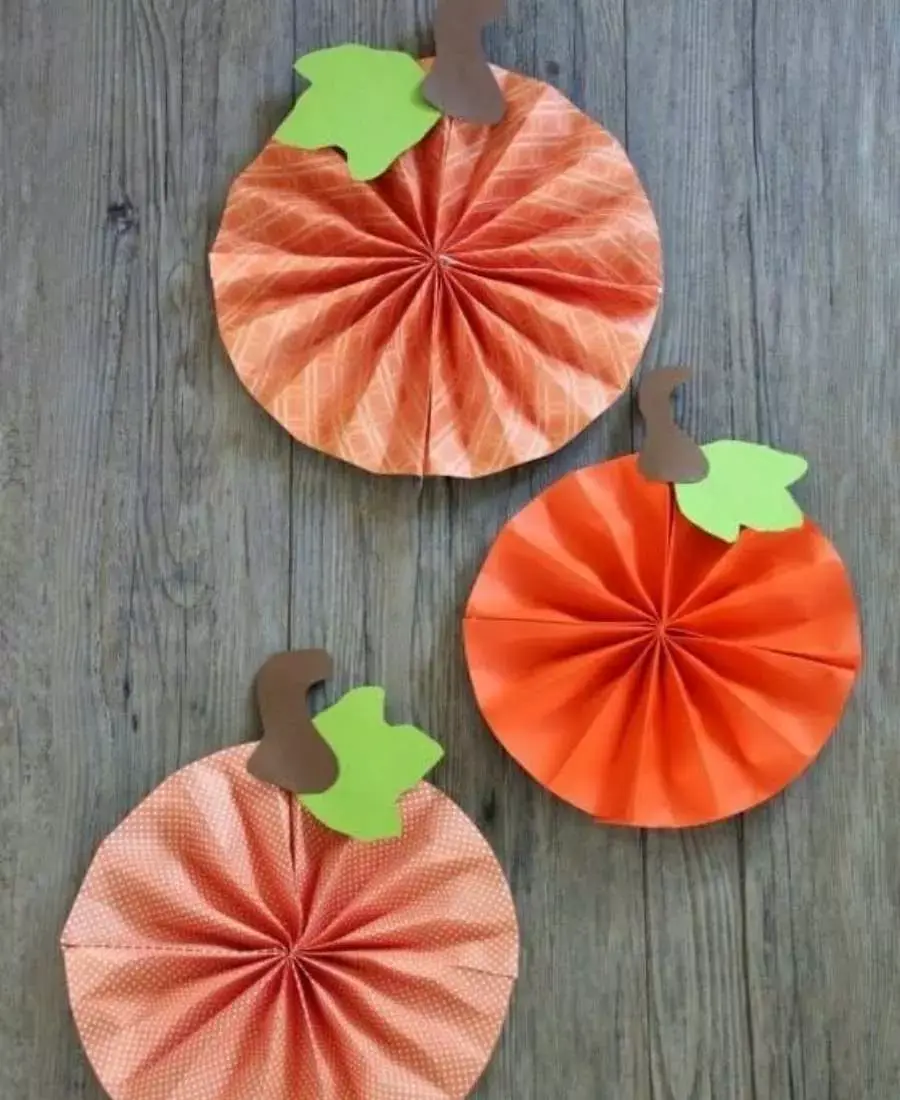 Decoração com dobraduras de papel em formato de abóboras.