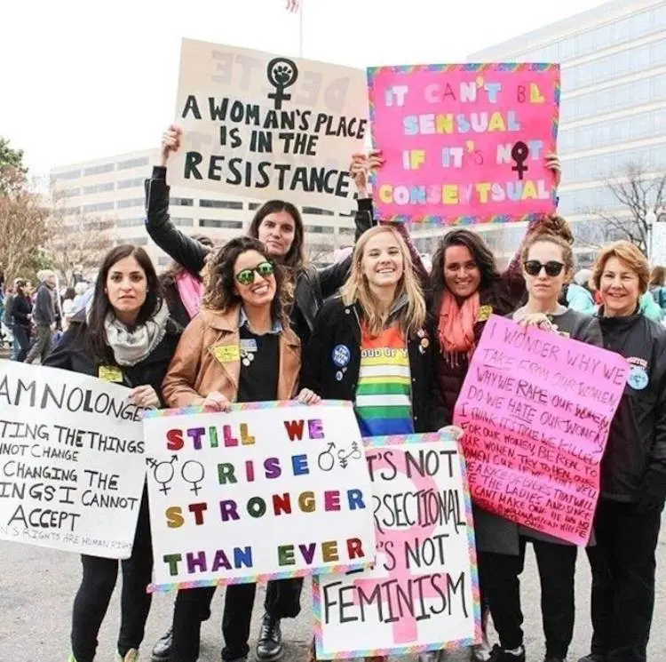 Foto de mulheres com cartazes em protesto sobre direito das mulheres
