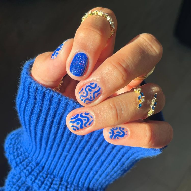 Unhas curtas em azul abstrato e filha única azul com glitter