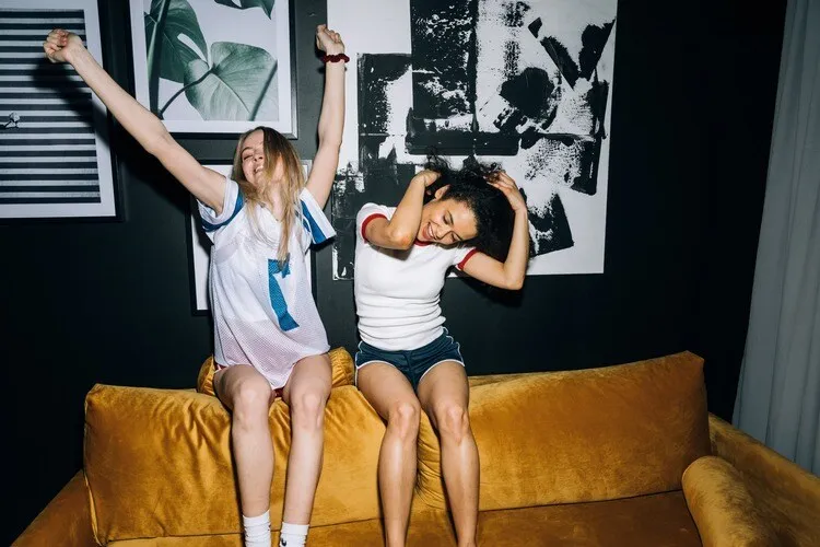 Duas meninas dançando em um sofá
