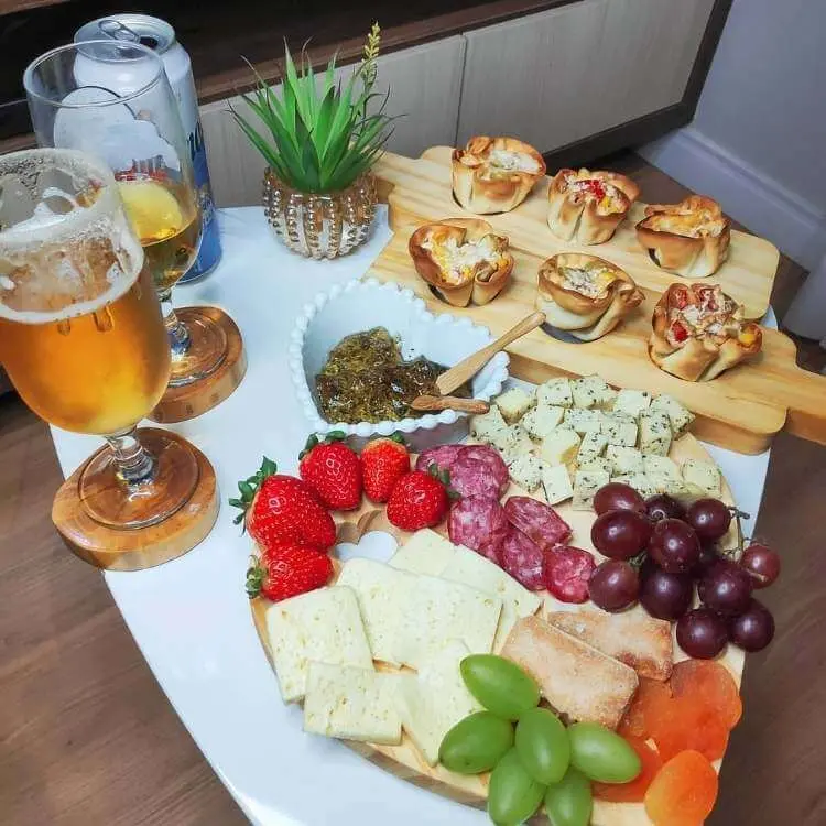 Mesa posta com cerveja e tábua de frios 