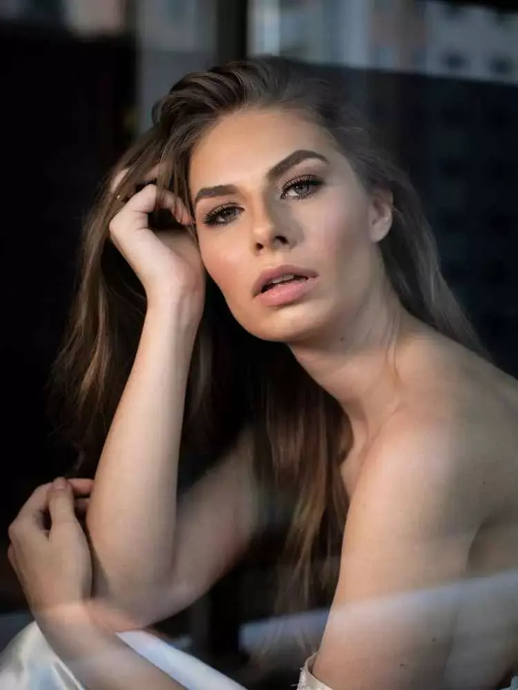 Mulher com mais de 30 anos em ensaio fotográfico, usando vestido de seda e maquiada
