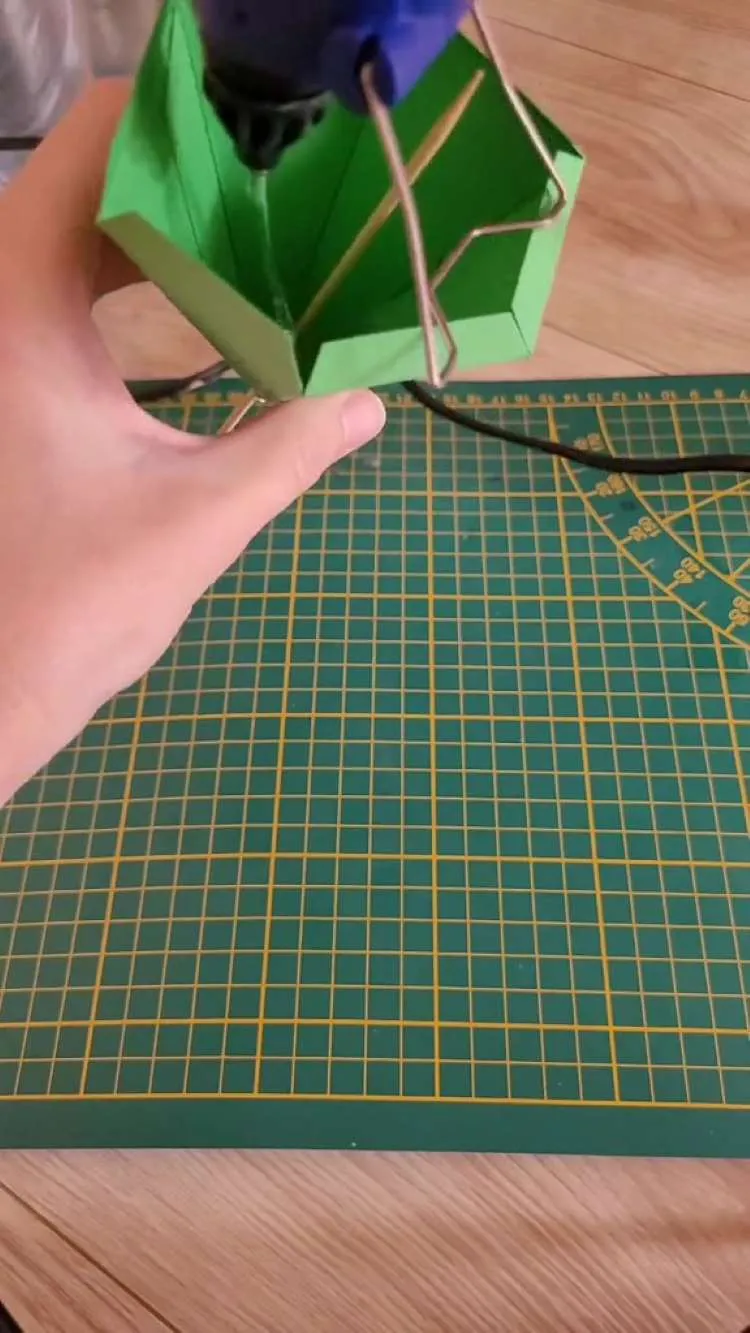 Fixando palito de madeira com cola-quente do passo a passo de prisma para tiara de Halloween
