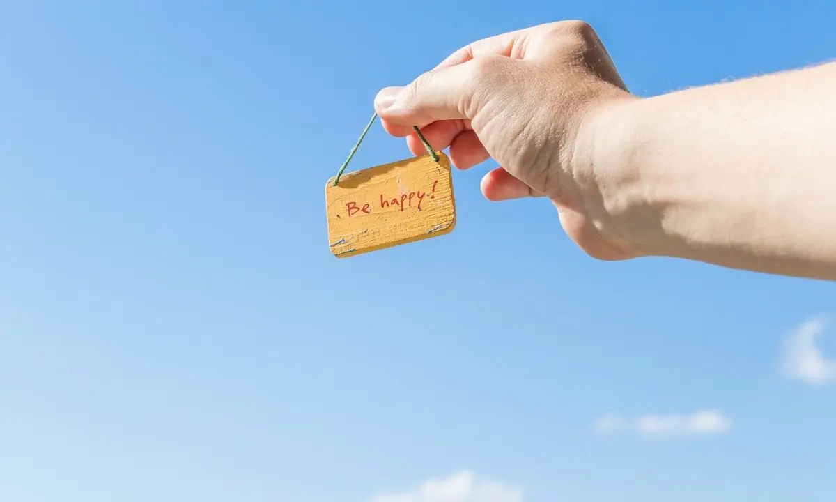 mão apontando para frase "be happy" - vender milhas