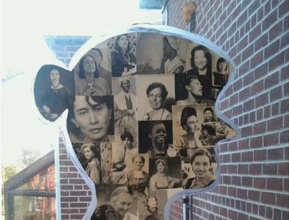 placa em formato de mulher com fotos de mulheres dentro