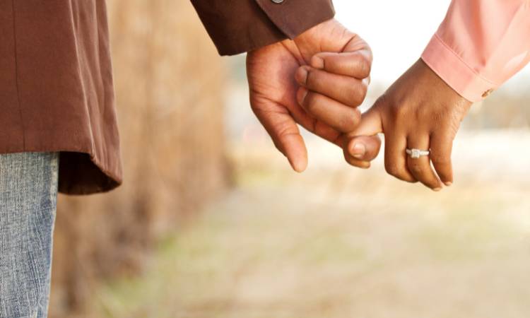 Casal de mãos dadas.