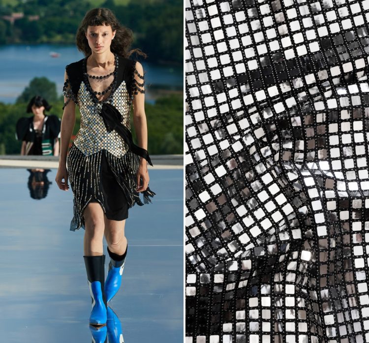 Modelo desfile marca Louis Vuitton Resort 2022 com top em visual grid prateado, saia preta e botas azuis