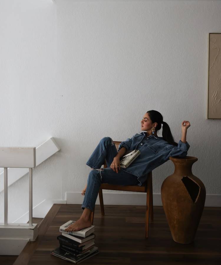 A imagem destaca uma calça jeans skinny de lavagem média, com detalhe desfiado no joelho, tendência para 2025. O look all-denim combina conforto e estilo, reforçando a versatilidade do jeans em produções modernas e elegantes para qualquer ocasião.