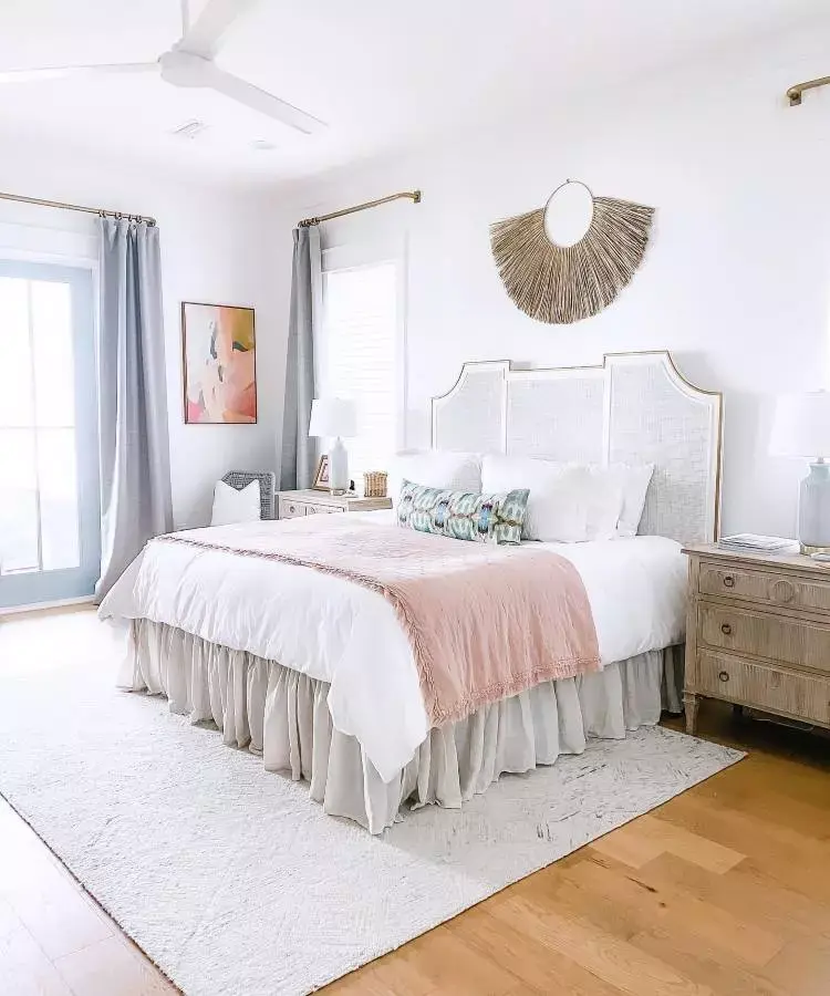 Quarto de casal com cama confortável, tapete, quadro e decoração de palha na parede
