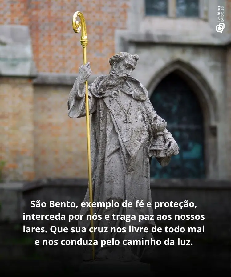 Uma estátua de pedra de São Bento, com barba e vestes, segura um báculo dourado e um livro. Ao fundo, uma igreja de tijolos e uma porta em arco. Texto sobre oração a São Bento na frente da imagem.