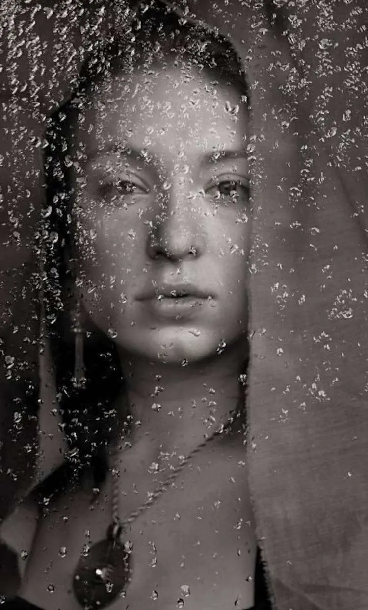 Foto de mulher na janela com chuva