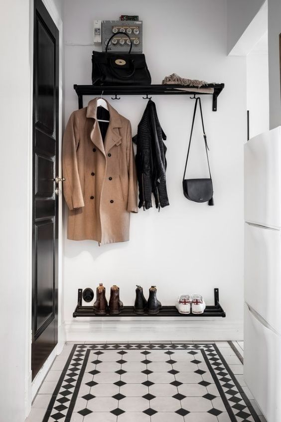 Hall branco e preto pequeno com prateleira com bolsa, espaço para pendurar bolsas e casacos e sapateira suspensa 