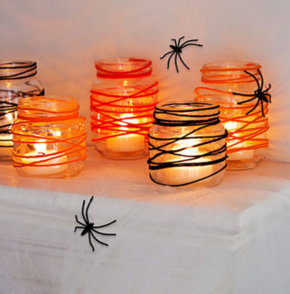 Potes de vidro com velas, barbantes e aranhas. Decoração de Halloween com vidro, e velas - Halloween em casa.