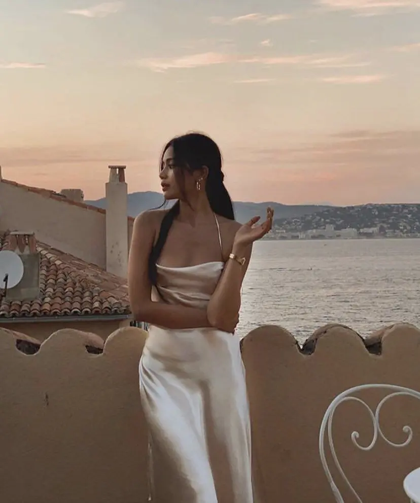 Frase para foto pensativa mulher veste sleep dress branco de cetim e usa relógio e brinco dourado