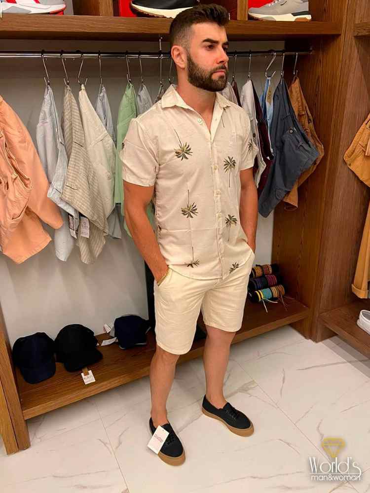 Roupas masculinas para Ano Novo: camisa de botões off white com estampa de palmeiras + short jeans off white.