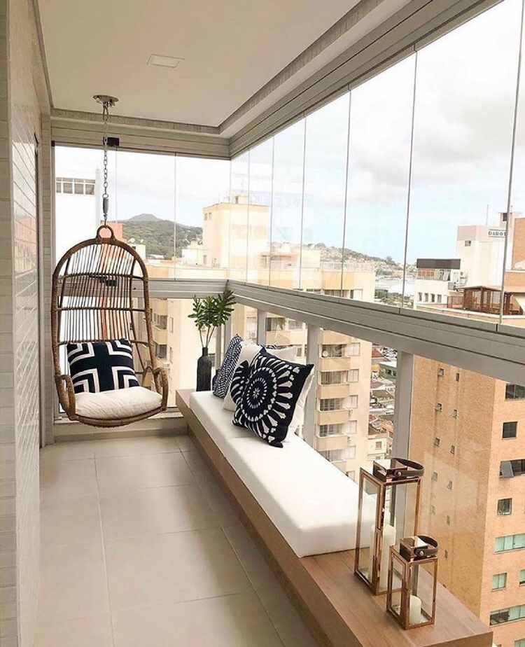 varanda aberta com banco branco e balanço redondo de madeira