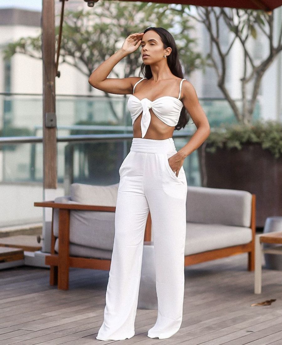 Mulher usando looks de ano novo com cropped branco e calça branca