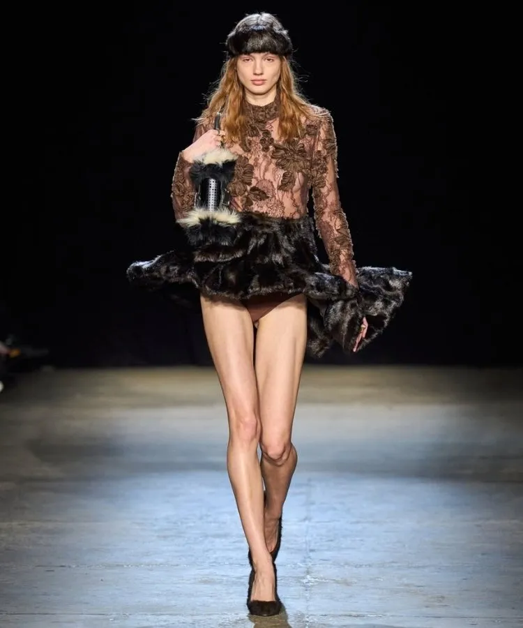 Foto de modelo usando blusa de renda e pernas à mostra, uma das tendências da NYFW Outono Inverno 2026
