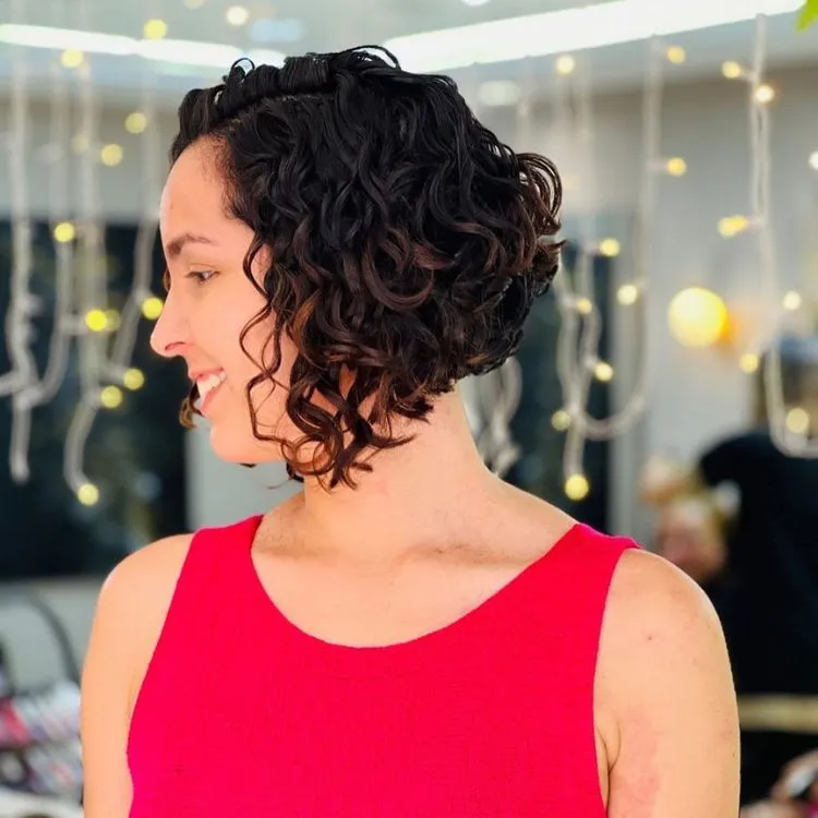 Mulher de pele clara com cabelo chanel de bico castanho enrolado