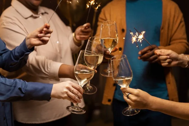 Mãos brindando com champnhes e velas.
