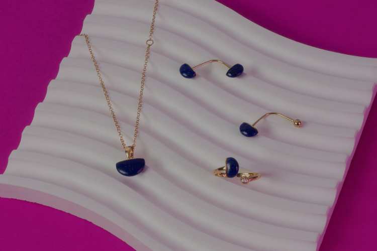 joias com pedras azul em fundo branco e roxo