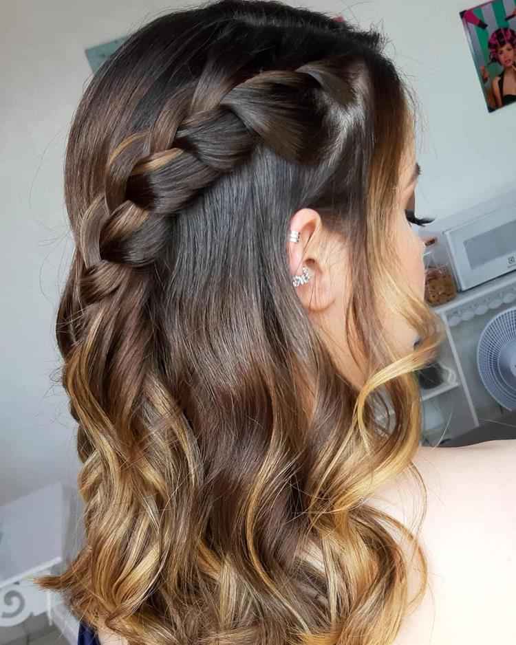 mulher com penteado de trança lateral em cabelo castanho com luzes