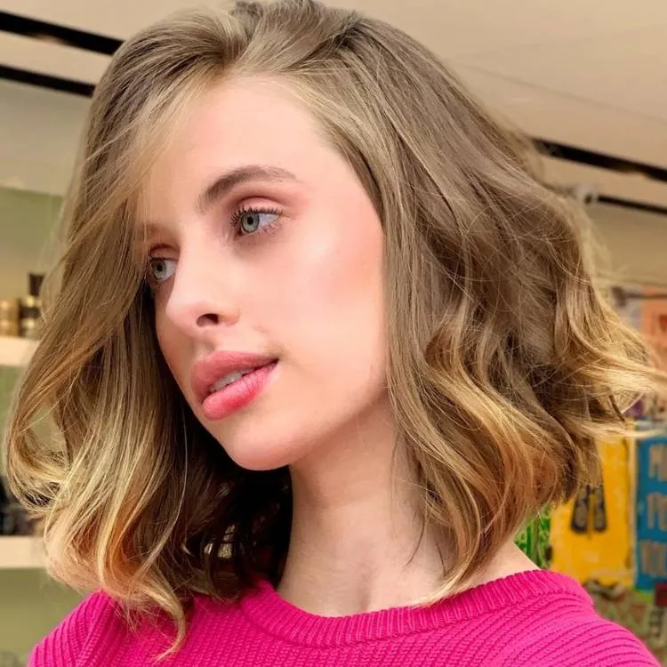Mulher de pele clara com cabelo chanel médio loiro