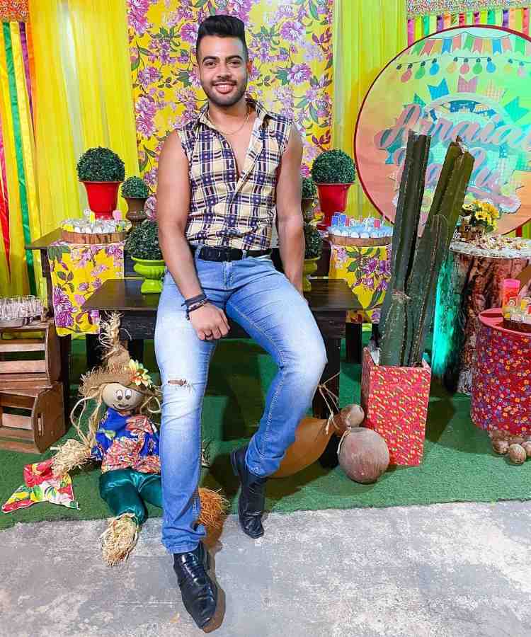 Homem com look de festa junina: colete xadrez e calça jeans