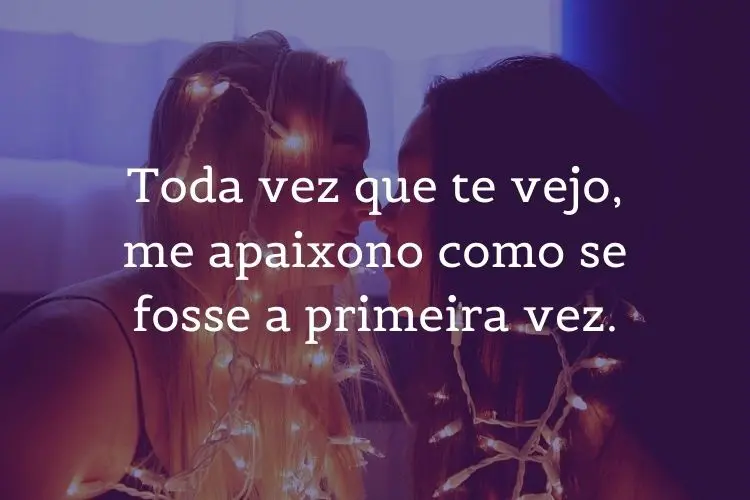 Foto de duas mulheres quase se beijando, com fio de pisca-pisca no corpo e frase "Toda vez que te vejo, me apaixono como se fosse a primeira vez."