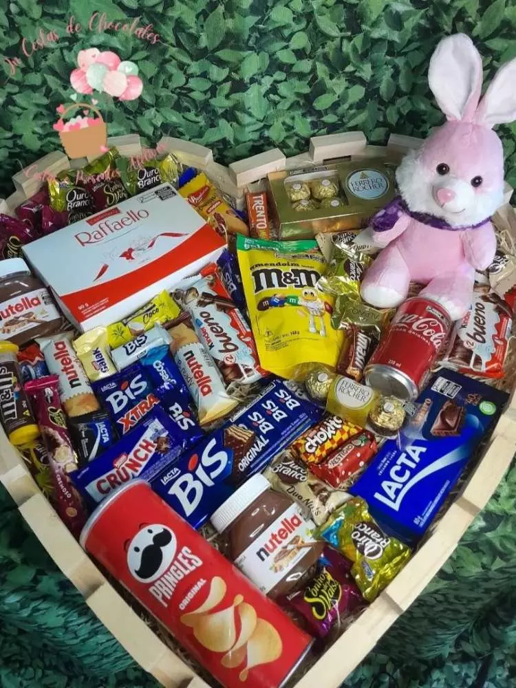 Cesta de Páscoa com pelúcia de coelho, inúmeros doces e batata chips