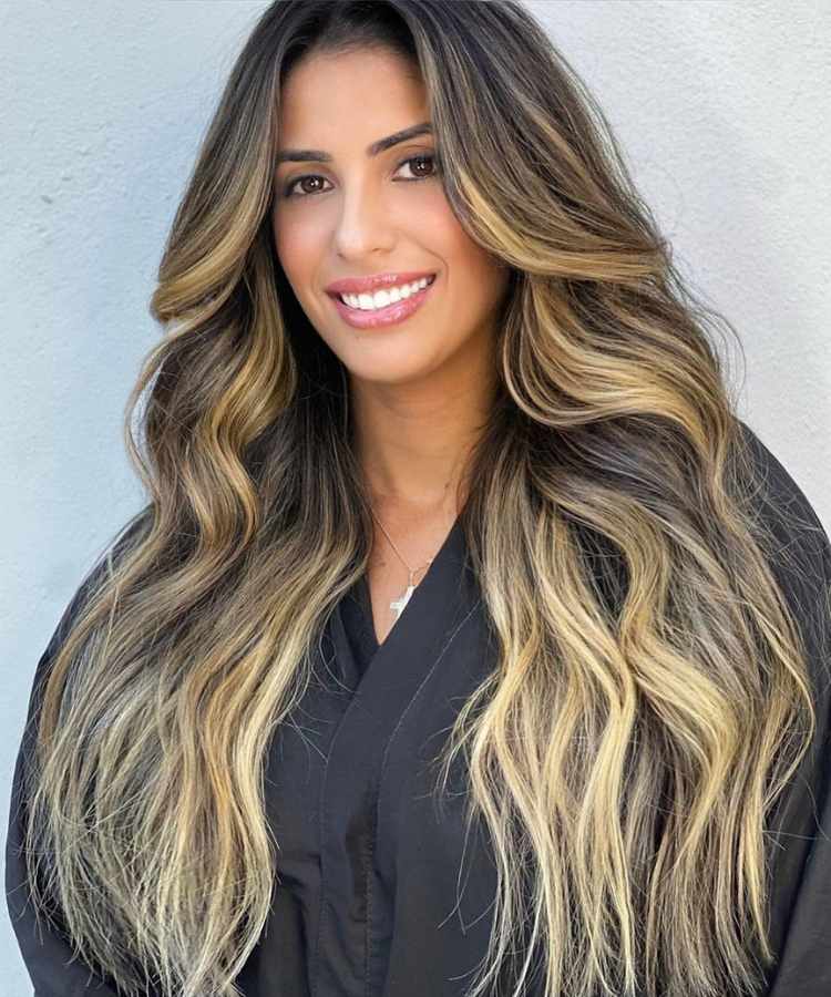Corte de cabelo longo com franja curtain bangs.