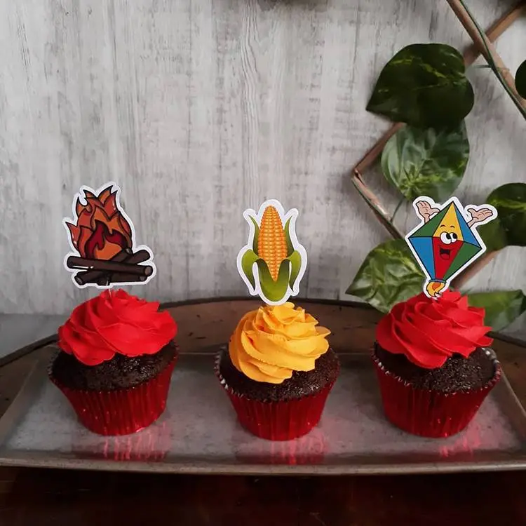 Cupcakes de chantily vermelhos e amarelo, com topper de fogueira, milho e balão
