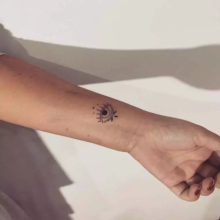tatuagem de olho no pulso de pessoa de pele clara, na parte interior, meio de lado 