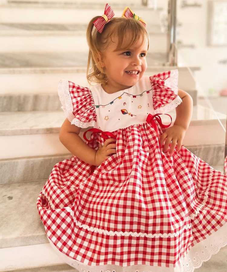 Menina com vestido xadrez vermelho para festa junina