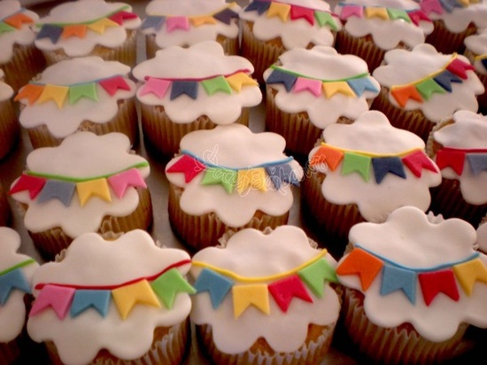 A imagem representa decorações de festa junina: docinhos decorados com pasta americana e bandeirinhas