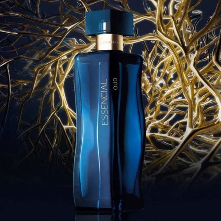 Um frasco de perfume azul escuro, "ESSENCIAL OUD", com um design elegante e curvado, repousa sobre uma superfície reflexiva. O fundo dourado e abstrato evoca a riqueza e a profundidade da fragrância.

