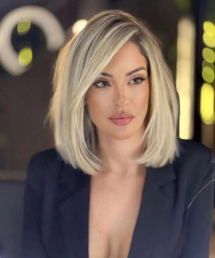 Mulher com corte de cabelo médio liso loiro franja diagonal