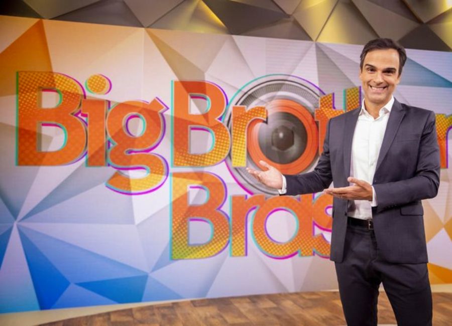 Tadeu Schmidt em frente ao logo do BBB 23