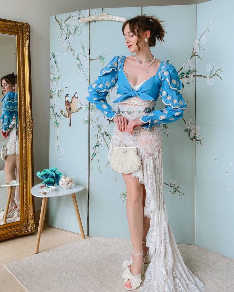 Look mermaidcore: top Azul sobre top de renda + saia rendada + o salto de laço + bolsa com formato de concha
