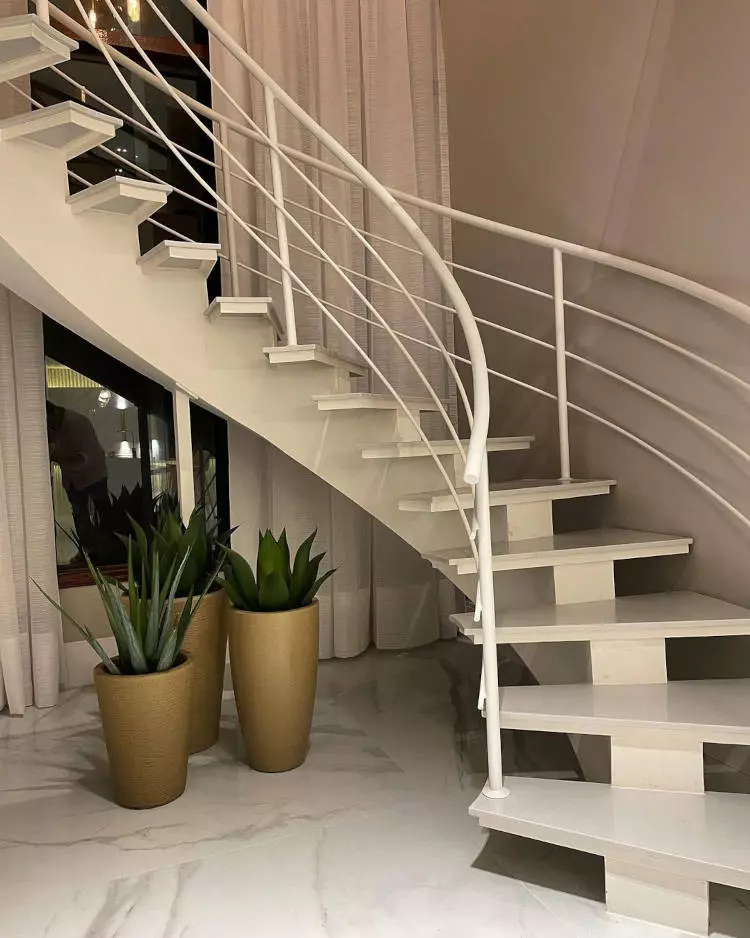 Escada redonda com degraus fixados em base estreira,