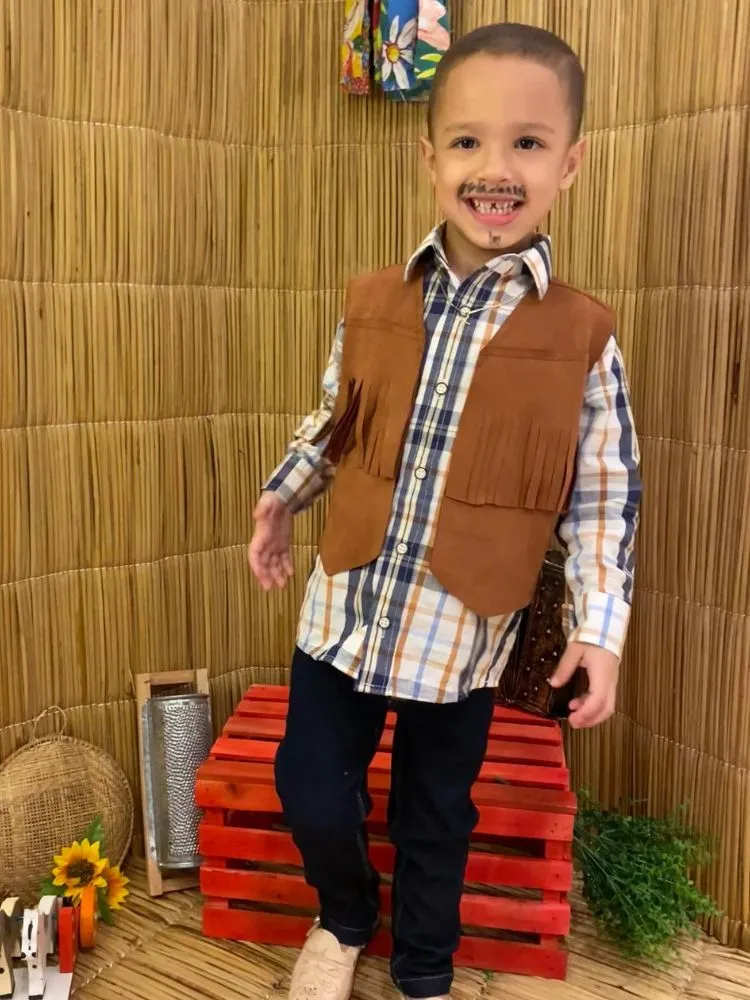 Menino de pele clara usando camisa xadrez, colete marrom, calça e barba e bigode fake 