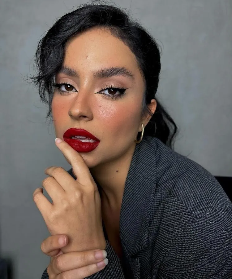 Foto de mulher usando maquiagem com lábios vermelhos, exemplificando como escolher a melhor cor de batom