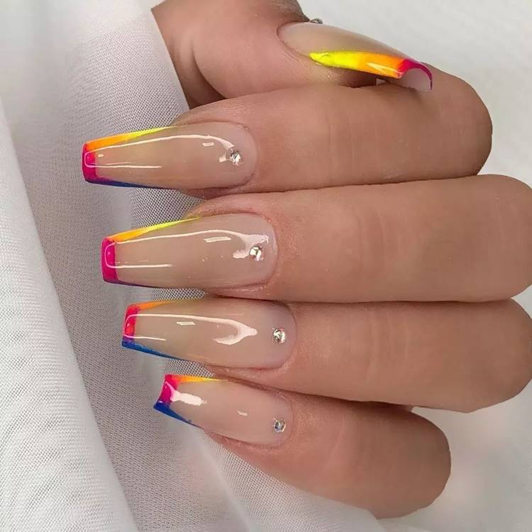 Mão com unhas arco-íris LGBTQIA+: Polegar: nude com francesinha quadrada cor arco-íris com 1 pedrinha na cutícula Indicador: nude com francesinha quadrada cor arco-íris com 1 pedrinha na cutícula Médio: nude com francesinha quadrada cor arco-íris com 1 pedrinha na cutícula Anelar: nude com francesinha quadrada cor arco-íris com 1 pedrinha na cutícula Mínimo nude com francesinha quadrada cor arco-íris com 1 pedrinha na cutícula