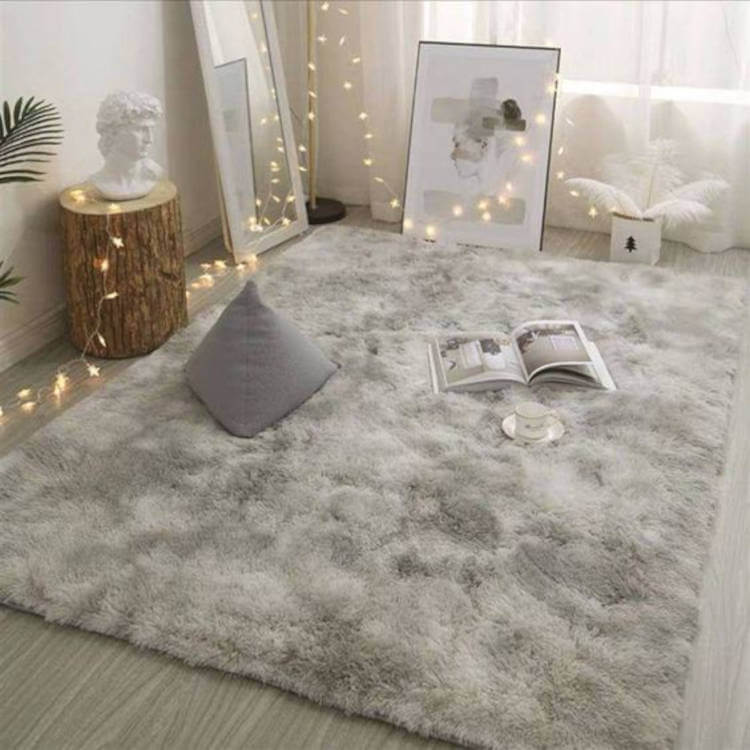 Espaço aconchegante para meditar, com tapete felpudo, busto de homem na cor branca, quadro no chão, espelho apoiado na janela, planta ao canto e fios com lâmpadas