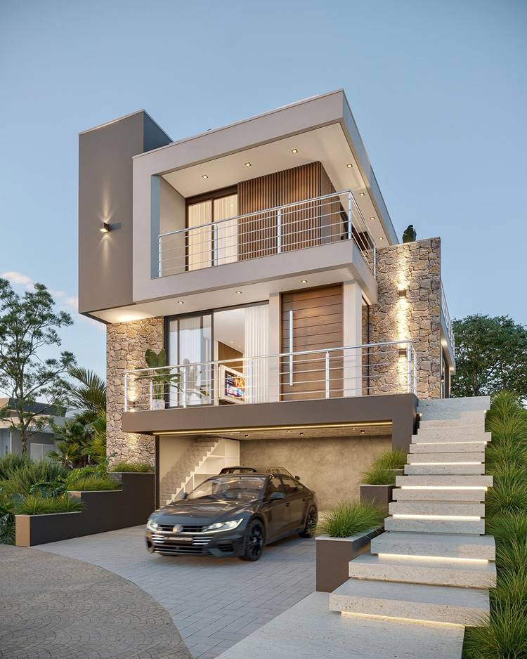 A imagem mostra uma casa moderna de dois andares com paredes claras e detalhes em pedra. A casa tem uma garagem aberta com um carro escuro, varandas com grades e uma entrada iluminada. A casa está rodeada de plantas e árvores bem cuidadas. O céu está no crepúsculo, dando um brilho suave à cena.