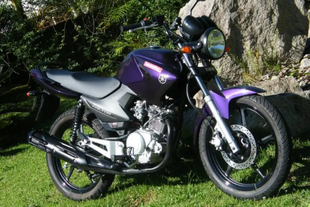 Imagem de uma Yamaha Factor 125 preta e roxa Imagem de uma Yamaha Factor 125 preta e roxa.